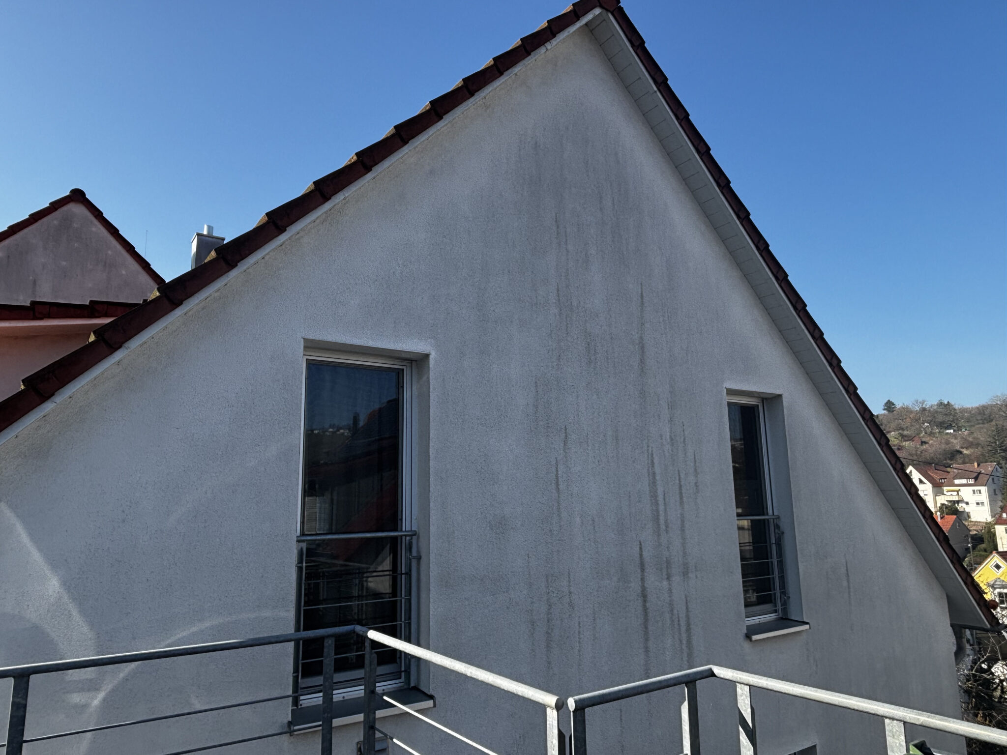 Hausfassade mit Grau-Schleier vor der Fassadenreinigung