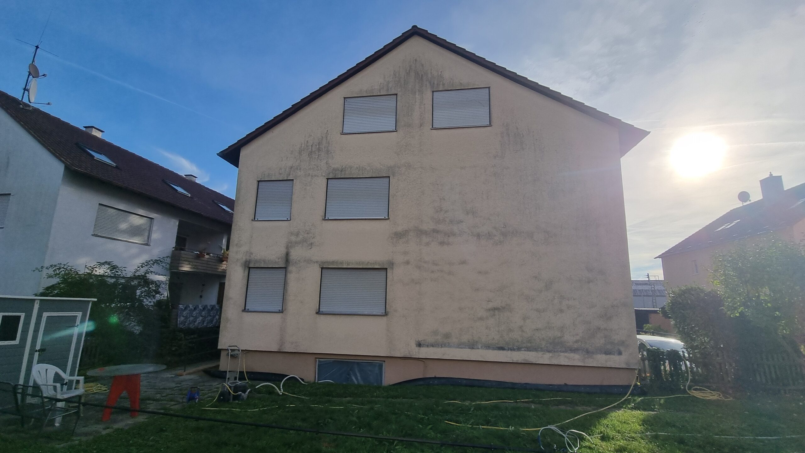 Fassadenreinigung Kosten: Stark verschmutzte Hausfassade mit Algenbefall in Ditzingen-Heimerdingen vor der Reinigung