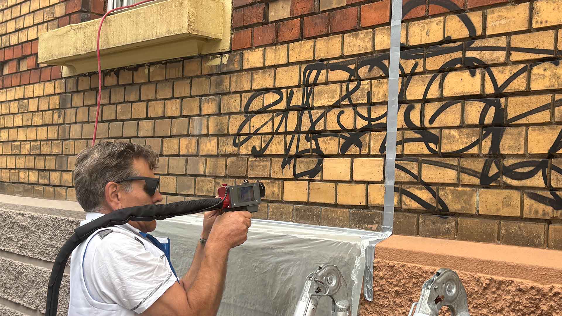 Mitarbeiter von Hein Fassadenreinigung bei einer Graffiti Entfernung mit Laser