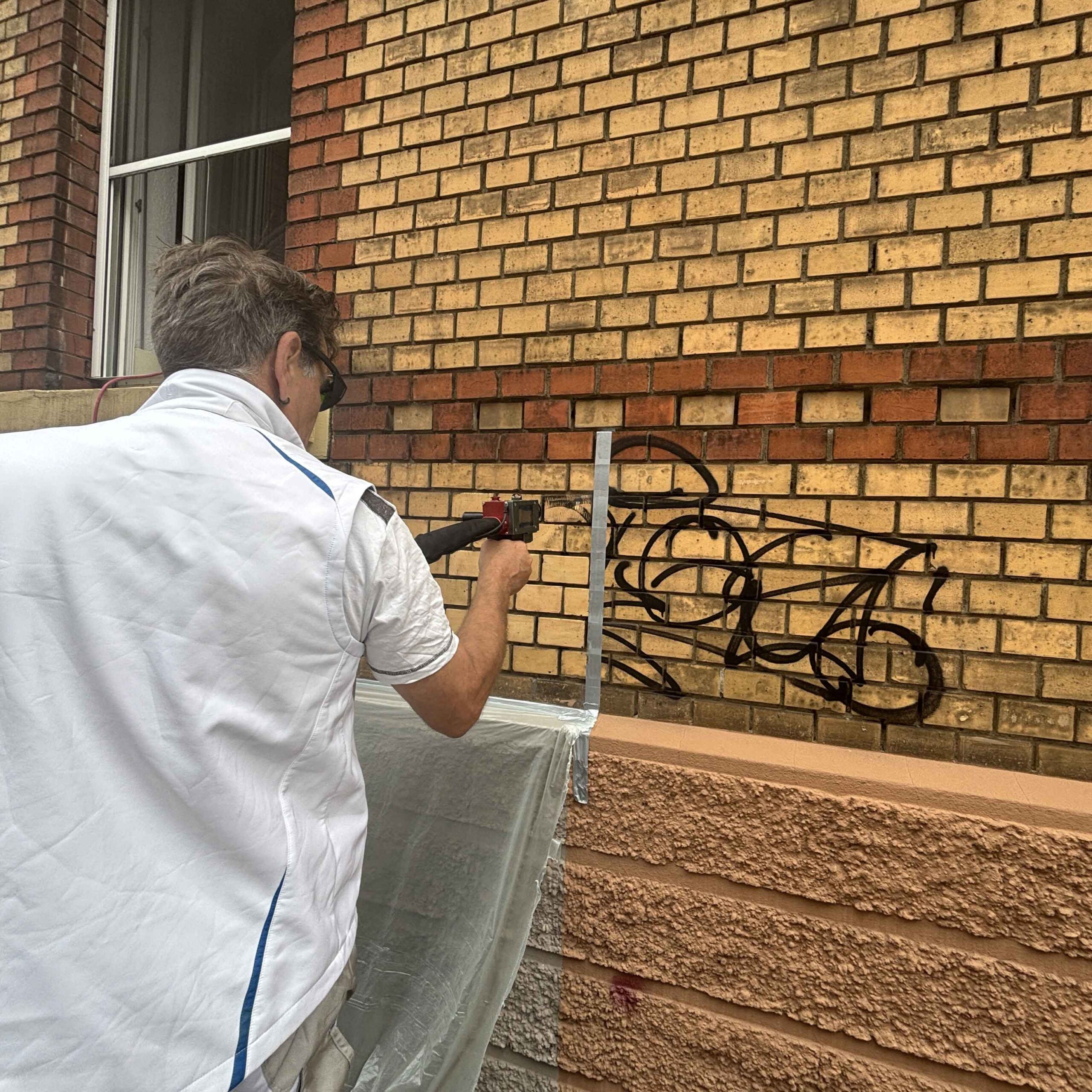 Mitarbeiter von Hein Fassadenreinigung bei einer Graffitientfernung